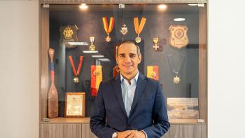 Un hombre frente a una vitrina de trofeos