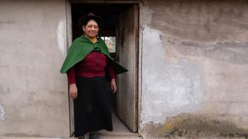 A woman standing in the doorway of her home.