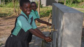 School children washing their hands at a hand washing station in school