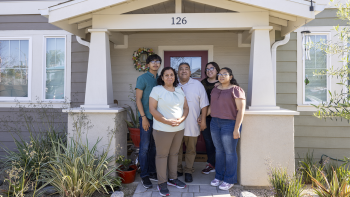 Family standing in front of house.