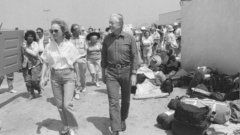 President and Mrs. Carter walking with a crowd of volunteers.