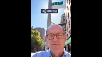 Jonathan Reckford selfie shot in front of 6th Street sign in New York City.