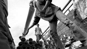 Workers unloading construction materials from a barge in Banda Aceh, Indonesia