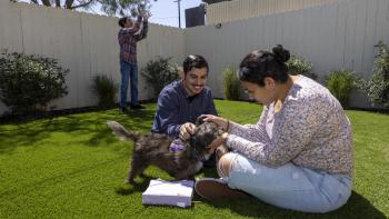  The Chavez family hang out with their dog Scruffy in the common area of the community where they live. 