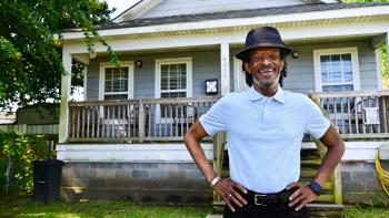Habitat homeowner Michael Harris stands outside his home in New Orleans.