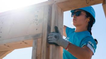 A volunteer works on a wall at the Carter Work Project build site.