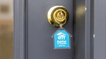 key in lock with blue house-shaped Habitat keychain.