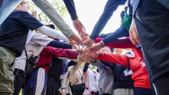 Japanese volunteers putting their hands together for a group photo