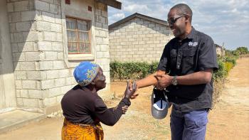 Habitat Zambia Board member greets homeowner. 
