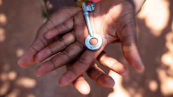 A close-up of a child's hands holding a key.