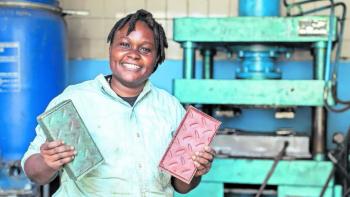 Woman holding up two recycled plastic bricks