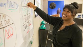 Woman writing on dry erase board