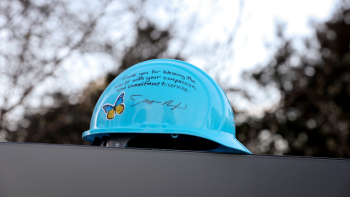 Blue hard hat with butterfly sticker and signed by Habitat CEO Jonathan Reckford with the message "Thank you for blessing the world with your compassion and commitment to service"