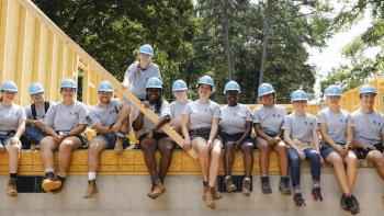 Large group of AmeriCorps members smiling on build site