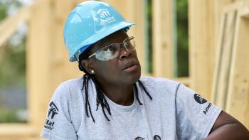 AmeriCorps member wearing hardhat and safety glasses on build site