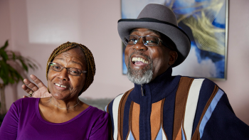 Regina and Larry in their home with big smiles