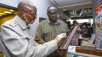 Two men look at prototype at ShelterTech Kenya accelerator.