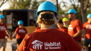 Group of Habitat volunteers hold hands to pray