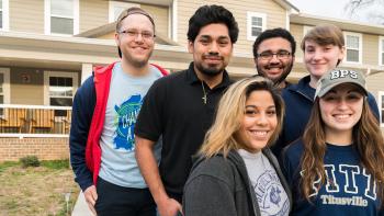 Group of six student volunteers smiling together