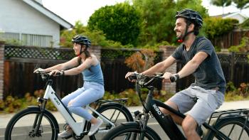 Woman and man on bikes smiling. 