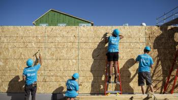 Volunteers work on an exterior wall during the Carter Work Project. 