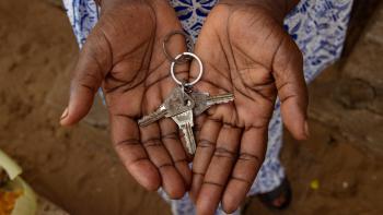 Two hands face the camera, palms up. In them are a set of keys, possibly to a home.
