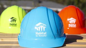 Bright green, bright blue and orange hard hats featuring the Habitat for Humanity logo.