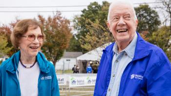 President and Mrs. Carter standing together outside smiling.