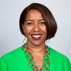 A headshot of Natasha Reid Rice in a green blouse.