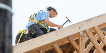 AmeriCorps volunteer hammering on roof