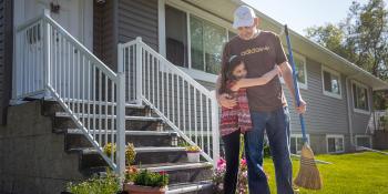 Child hugs father outside their Habitat home