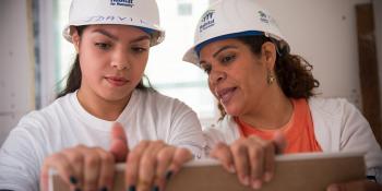 Future homeowners lift drywall