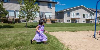 Child plays outside a Habitat house.