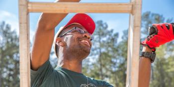 Collegiate Challenge volunteer climbs ladder