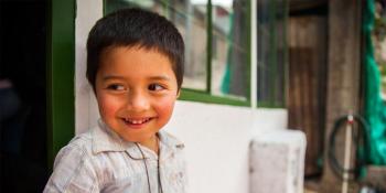 boy standing in front house