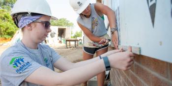 Katy Karl and Julie McNally install siding during the annual Habitat AmeriCorps Build-a-Thon.
