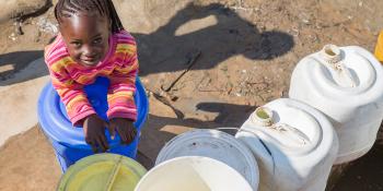 a girl with water tanks in Zambia