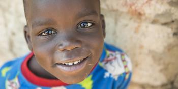 photo: a boy smiling, wearing pyjamas with Christmas trees