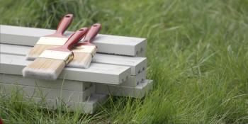 Paintbrushes and wood on grass