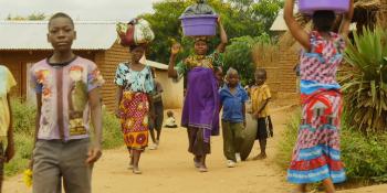 Malawi women using their heads to carry buckets of water.