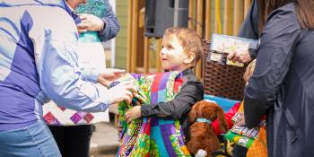 Little boy receives quilt.