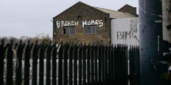Photo: "broken homes" written on a broken house