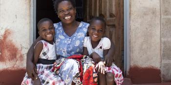 Photo: family sitting on stairs in front of their house in Zambia