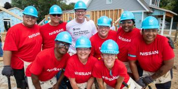 Nissan volunteers with Jonathan Reckford on a build site.