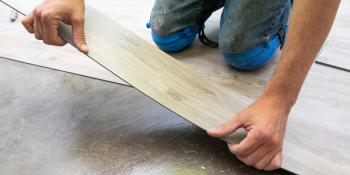 Volunteer lays down flooring.