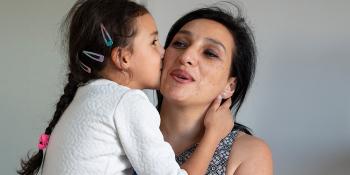 a child giving a kiss to her mother