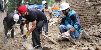 Youth volunteers help clear rubble.