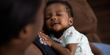 Baby being held by mother. 