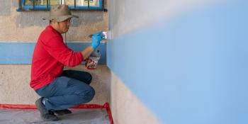 Volunteer painting a wall.
