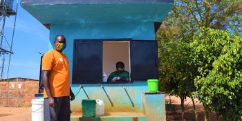 Morrix stands beside a water kiosk.